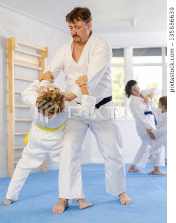 Father and son training judo fighting techniques Father and son training judo fighting techniques 135886639