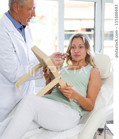 Experienced male cosmetologist consulting woman before facial treatments 135886693