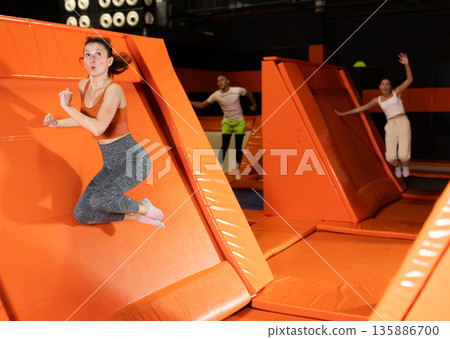 Emotional woman pushing off from angled surface in trampoline park Emotional woman pushing off from angled surface in trampoline park 135886700