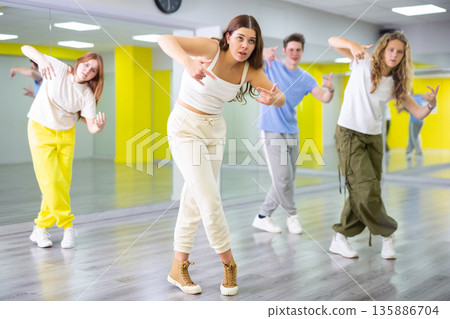 Young girl training breakdance Toprock moves in dance hall 135886704