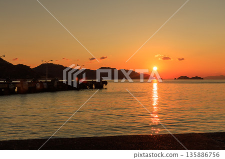 A tranquil sunset scene with the Seto Inland Sea sparkling in the setting sun and the breakwater of Yawatahama Port A tranquil sunset scene with the Seto Inland Sea sparkling in the setting sun and the breakwater of Yawatahama Port 135886756