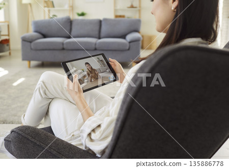 Young woman having videocall on tablet at home 135886778