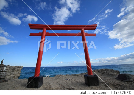 海邊的紅色鳥居,藍天白雲。 海邊的紅色鳥居,藍天白雲。 135887678