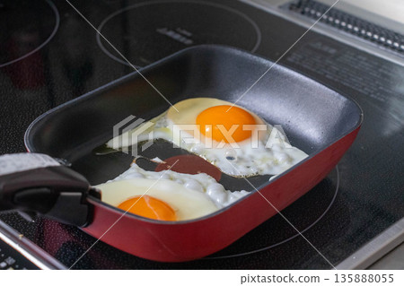 Cooking scene of fried eggs being cooked in a frying pan 135888055