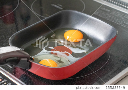 Cooking scene of fried eggs being cooked in a frying pan 135888349