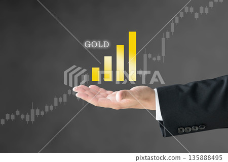 一位穿著西裝的男士舉著一張圖表，圖表顯示黃金價格上漲。 135888495