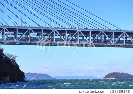 A train running under the Setouchi Ohashi Bridge (Setouchi Ohashi Line) seen from Kurohama Beach on Iwakuro Island A train running under the Setouchi Ohashi Bridge (Setouchi Ohashi Line) seen from Kurohama Beach on Iwakuro Island 135889378