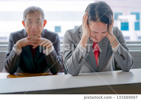Businessman holding his head under pressure 135889897