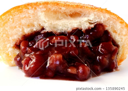 Cross section of anpan overflowing with red bean paste on a white background 135890245