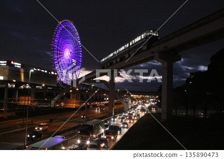 Osaka Monorail train passing on the Central Circular Line at night and the Ferris wheel at Expo City Osaka Monorail train passing on the Central Circular Line at night and the Ferris wheel at Expo City 135890473