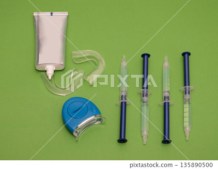 Teeth whitening equipment on green background 135890500