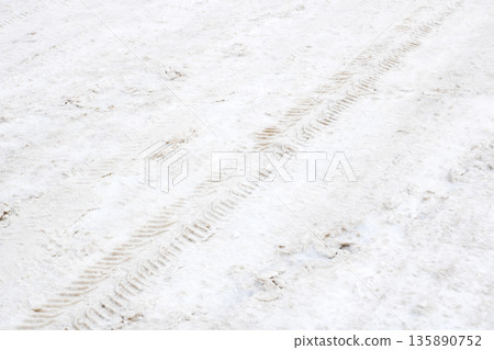 Serene winter scene, Quiet icy environment with snow and tire tracks conveying serenity Serene winter scene, Quiet icy environment with snow and tire tracks conveying serenity 135890752