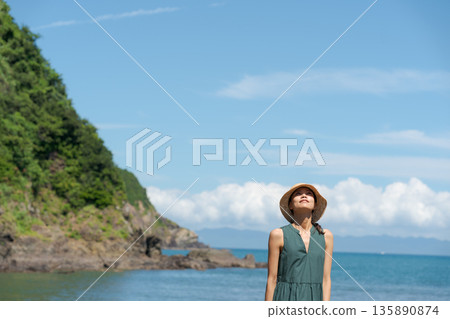 A woman walking along the beach 135890874