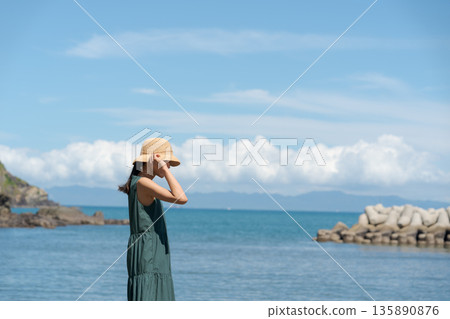 一個女人在沙灘上散步 135890876