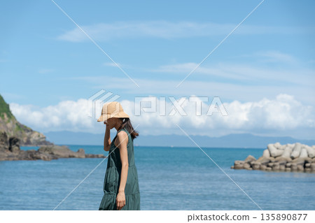 一個女人在沙灘上散步 135890877