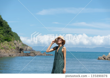 一個女人在沙灘上散步 135890878