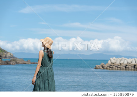 一個女人在沙灘上散步 135890879