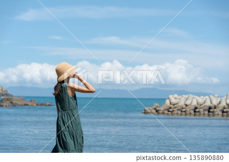 一個女人在沙灘上散步 135890880