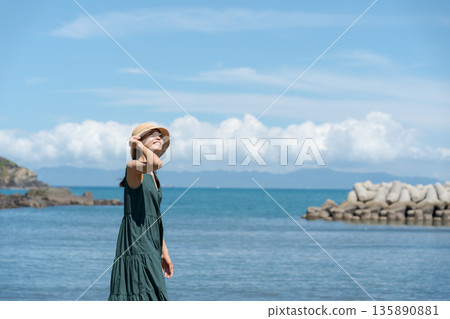 一個女人在沙灘上散步 135890881