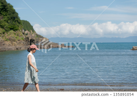 Girl playing at the seaside Girl playing at the seaside 135891054