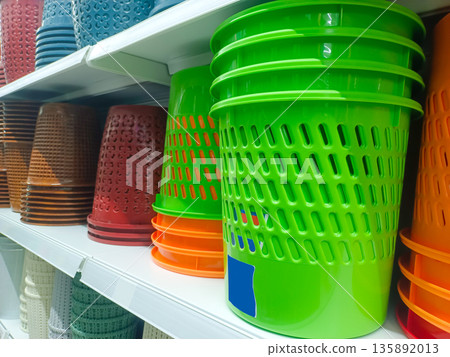 Stack of Bright Green Plastic Waste Bins and Storage Buckets on Retail Shelf 135892013