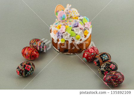 Colorful Easter cake with decorated eggs on gray surface Colorful Easter cake with decorated eggs on gray surface 135892109
