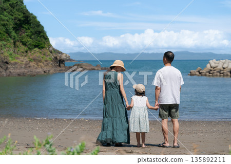 站立在海灘的父母和孩子 站立在海灘的父母和孩子 135892211