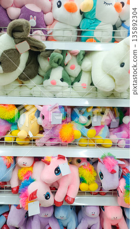 Colorful Unicorn and Rabbit Plush Toys on Retail Display Shelf 135892304