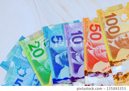 Canadian cash dollar, currency notes of five, ten, twenty, one hundred dollars are lined up 135893353