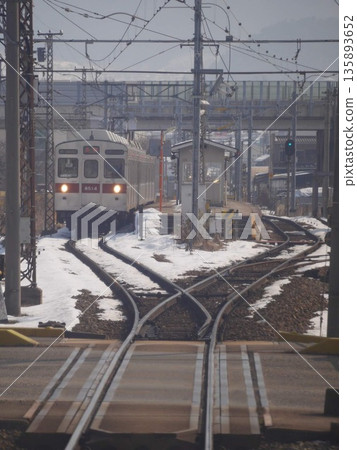 2015年1月,長野縣,長野電氣鐵道3500系列列車行駛在白雪皚皚的信州和岔路口。 2015年1月,長野縣,長野電氣鐵道3500系列列車行駛在白雪皚皚的信州和岔路口。 135893652