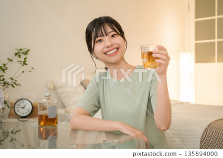 Young Asian woman having a drink in the bedroom at home (whisky, home drinking, drinking habits) Young Asian woman having a drink in the bedroom at home (whisky, home drinking, drinking habits) 135894000