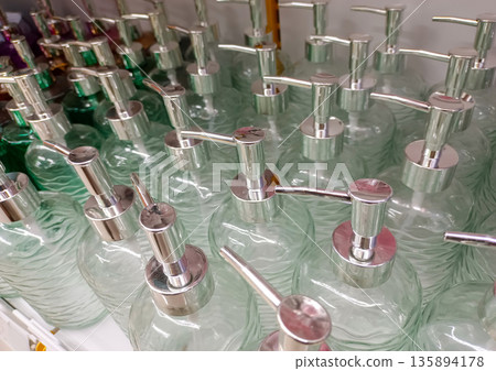 Transparent Glass Liquid Soap Bottles with Metallic Pump Head Perspective View on Store Shelf Transparent Glass Liquid Soap Bottles with Metallic Pump Head Perspective View on Store Shelf 135894178
