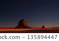 The stillness of the desert is broken by the energetic light trails of cars near the iconic monoliths 135894447