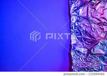 Crumpled aluminum foil reflecting abstract purple and blue light 135894460