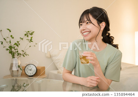 一位年輕的亞洲女性在家中臥室喝酒（在家喝酒、微醺、在家喝酒、喝酒） 135894464