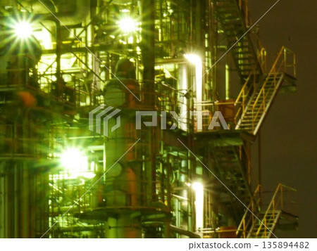 The elaborate piping and dazzling lights of a factory plant shining in the darkness of the night. January 25, 2015 Kawasaki City, Japan The elaborate piping and dazzling lights of a factory plant shining in the darkness of the night. January 25, 2015 Kawasaki City, Japan 135894482