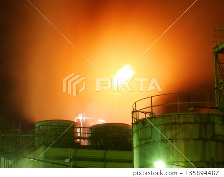Factory flare stacks and huge tanks illuminating the darkness of the night. January 25, 2015, Kawasaki City, Japan. 135894487
