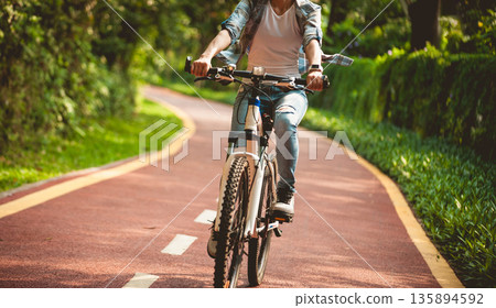 Fitness woman cycling in the park Fitness woman cycling in the park 135894592