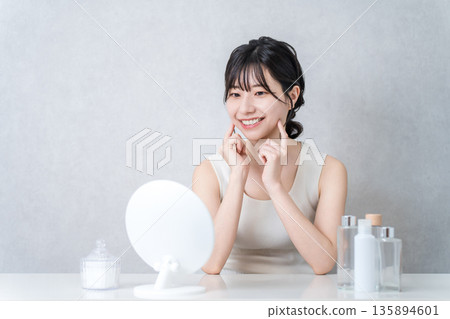 Young Asian woman looking in the mirror and doing beauty, skin care, facial care Young Asian woman looking in the mirror and doing beauty, skin care, facial care 135894601