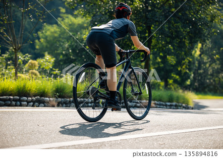 Cyclist riding bike at summer park 135894816