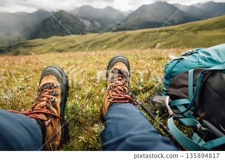 Woman backpacking on high altitude mountains top,sit on the grass Woman backpacking on high altitude mountains top,sit on the grass 135894817