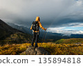 Woman backpacker hiking on high altitude mountains top 135894818