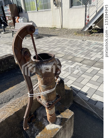 A rusty hand pump and a quiet street corner 135894945