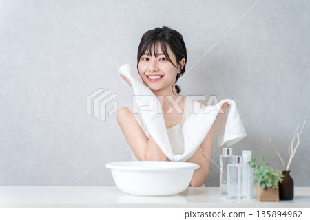 年輕的亞洲女人洗臉並用毛巾擦乾(洗臉) 年輕的亞洲女人洗臉並用毛巾擦乾(洗臉) 135894962