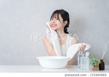 Young Asian woman washing her face and drying it with a towel (face wash) Young Asian woman washing her face and drying it with a towel (face wash) 135894969