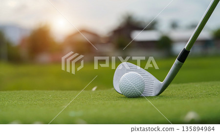 Golf clubs and golf balls on a green lawn in a beautiful golf course with morning sunshine. Golf clubs and golf balls on a green lawn in a beautiful golf course with morning sunshine. 135894984