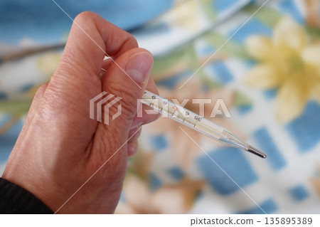 老人的手部體溫計 135895389