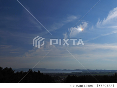 Vivid iridescent clouds appeared over Lake Inawashiro. They were striking and beautiful against the blue sky. Vivid iridescent clouds appeared over Lake Inawashiro. They were striking and beautiful against the blue sky. 135895821