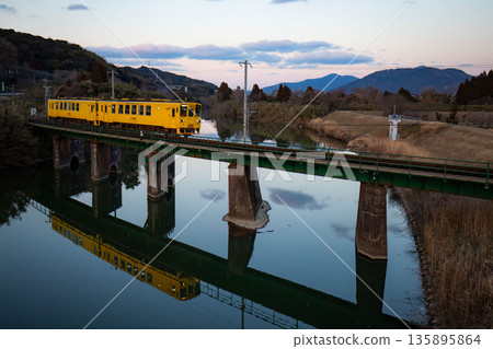 一列黃色列車駛過佐賀唐津線鐵路橋 一列黃色列車駛過佐賀唐津線鐵路橋 135895864