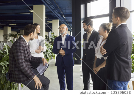 Diverse business team smiling in modern office during productive meeting Diverse business team smiling in modern office during productive meeting 135896028